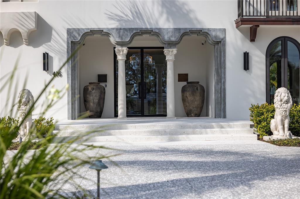 The exterior entrance features a stone portico with two columns, large urns, and lion statues — 416 BRIGHTWATERS BOULEVARD NE, ST PETERSBURG, FL