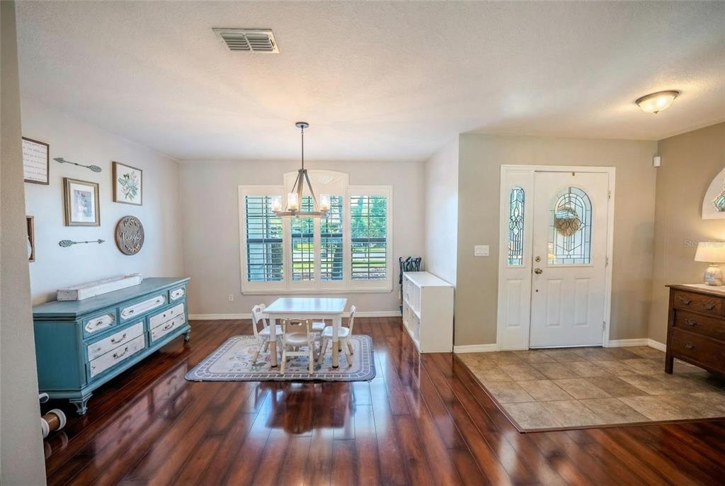 A dining area with a blue sideboard, a small table, and a tiled entryway — 4719 SE 32ND STREET, OCALA, FL