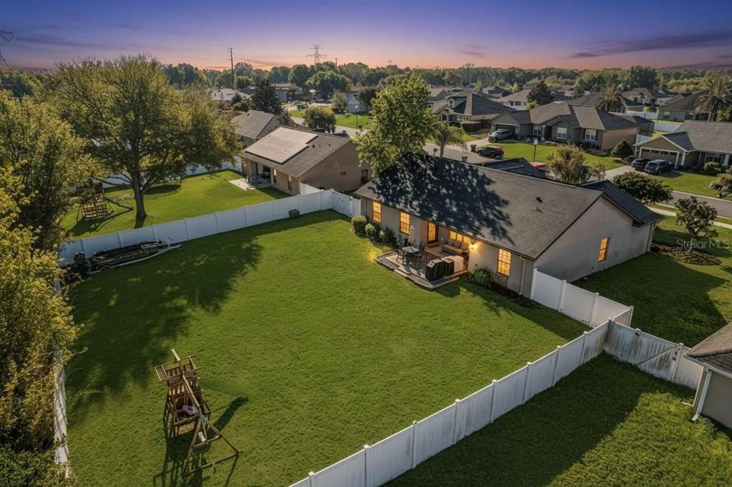 An aerial view of a suburban house with a large fenced backyard and patio — 4719 SE 32ND STREET, OCALA, FL