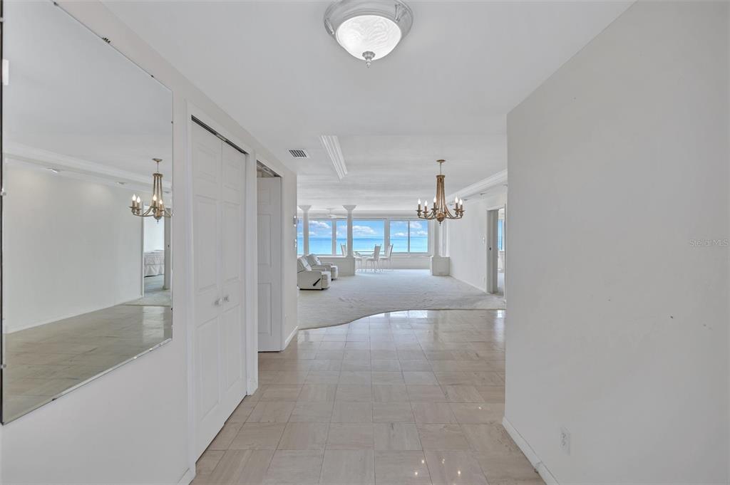 A tiled entryway leads into a carpeted living area with ocean views through large windows — 6140 MIDNIGHT PASS ROAD UNIT 904, SARASOTA, FL
