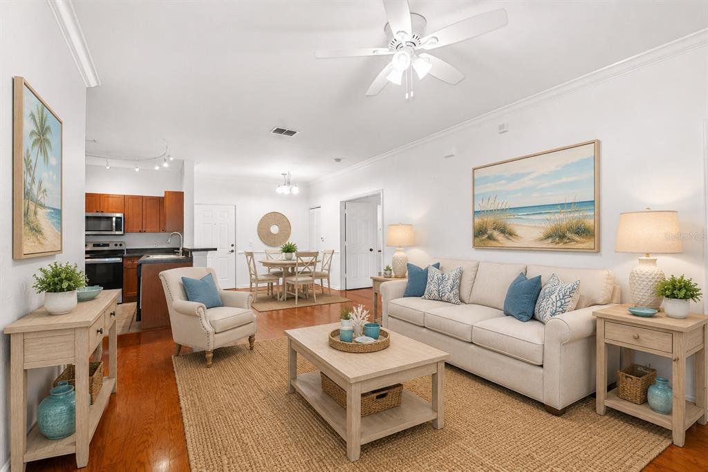 A living room with a beige sofa, coffee table, and an adjacent kitchen and dining area — 2250 PORTOFINO PLACE UNIT 239, PALM HARBOR, FL