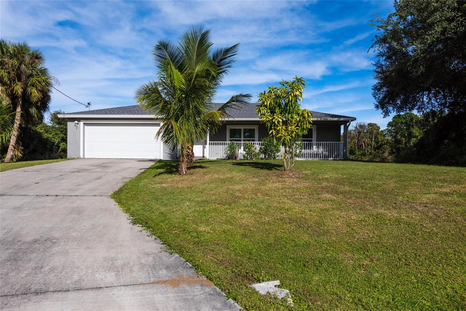 A single-story house with a white garage door, a front porch, and two small trees — 8007 Royal Court, FL 33935, FL