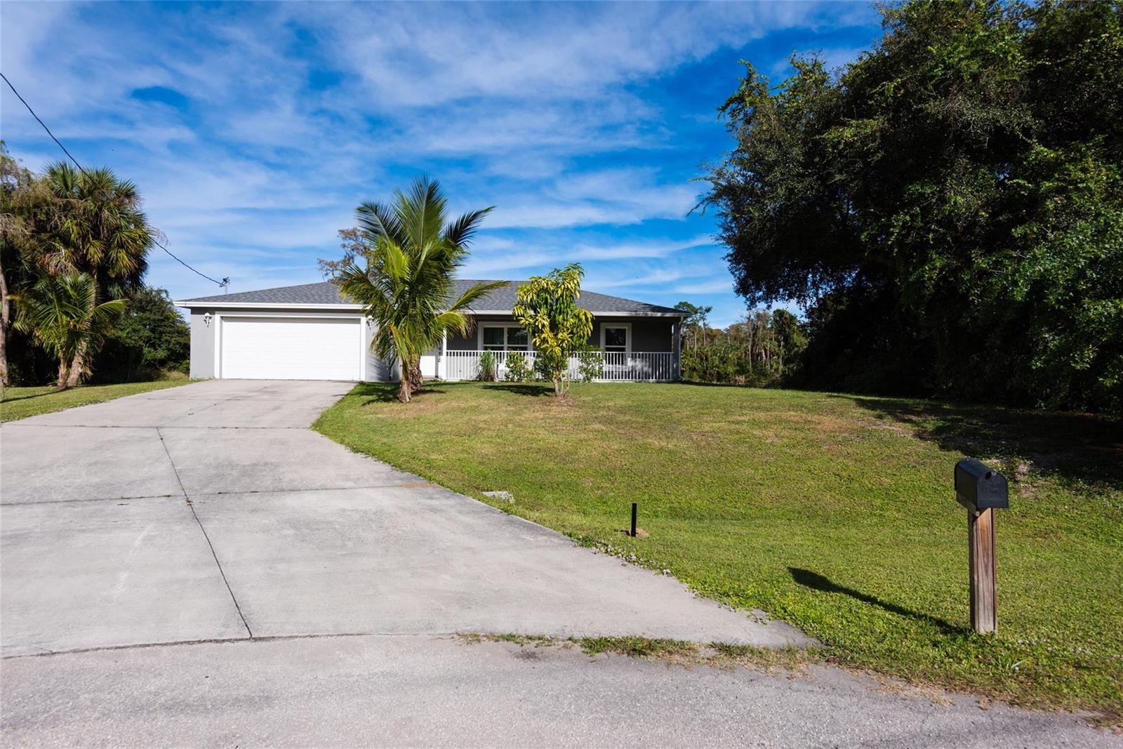 A single-story house with a white garage, a front porch, and a concrete driveway — 8007 Royal Court, FL 33935, FL