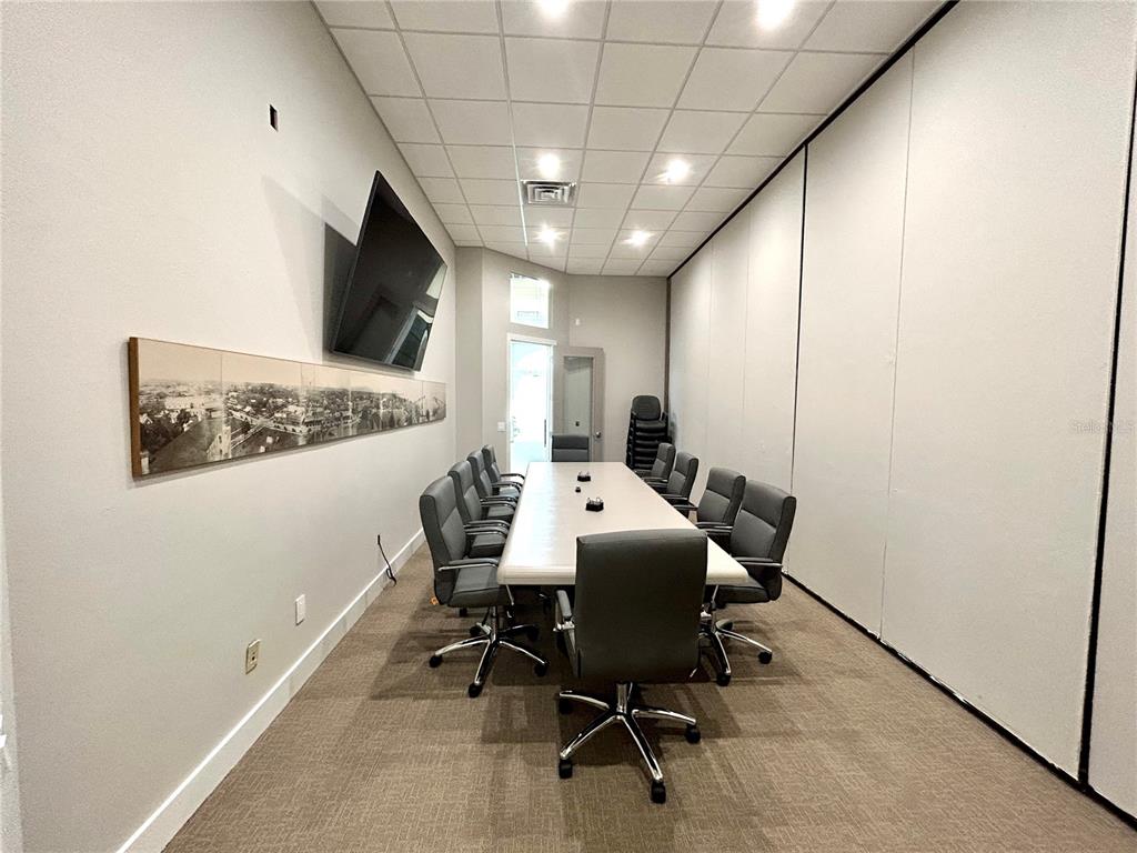 A conference room features a long table, gray office chairs, and a wall-mounted television — 1203 W MARION AVENUE, PUNTA GORDA, FL