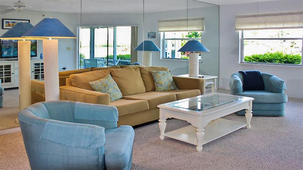A living room features a tan sofa, two blue armchairs, and a white coffee table — 1351 SIESTA BAYSIDE DRIVE UNIT 1351-D, SARASOTA, FL