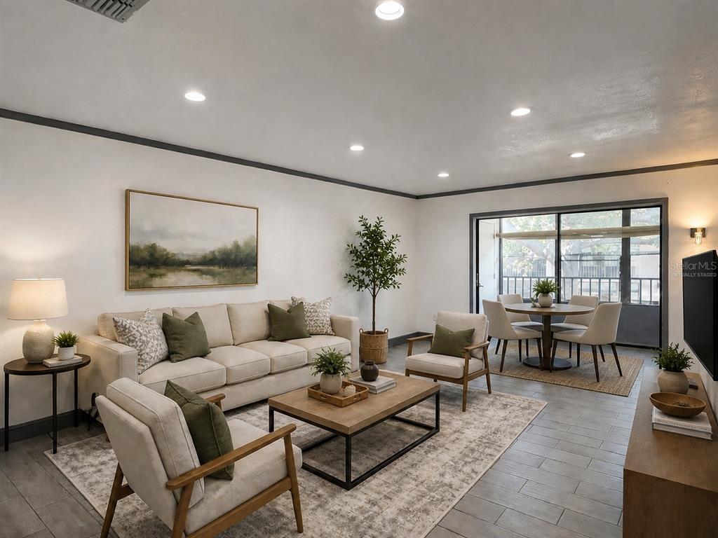 A living room with a sofa, two armchairs, a coffee table, and a dining area — 2275 62ND AVENUE N UNIT 5202, ST PETERSBURG, FL
