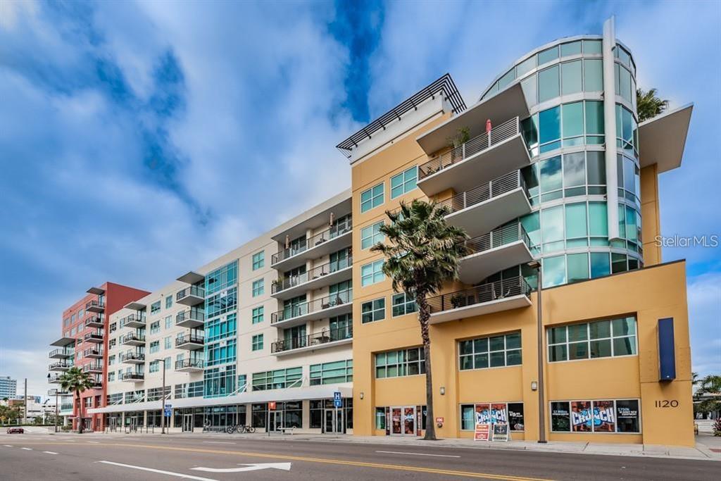 A multi-story apartment building with a curved glass facade and ground-level retail space — 1120 E KENNEDY BOULEVARD UNIT 1030, TAMPA, FL