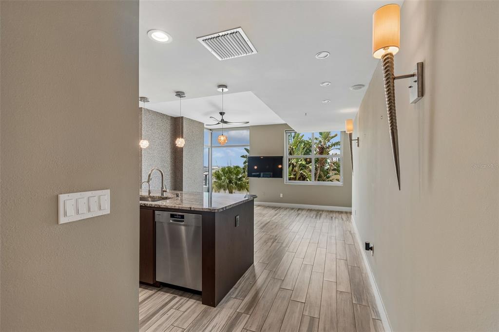 A kitchen island with a stainless steel dishwasher sits in an open-concept living space — 1120 E KENNEDY BOULEVARD UNIT 1030, TAMPA, FL