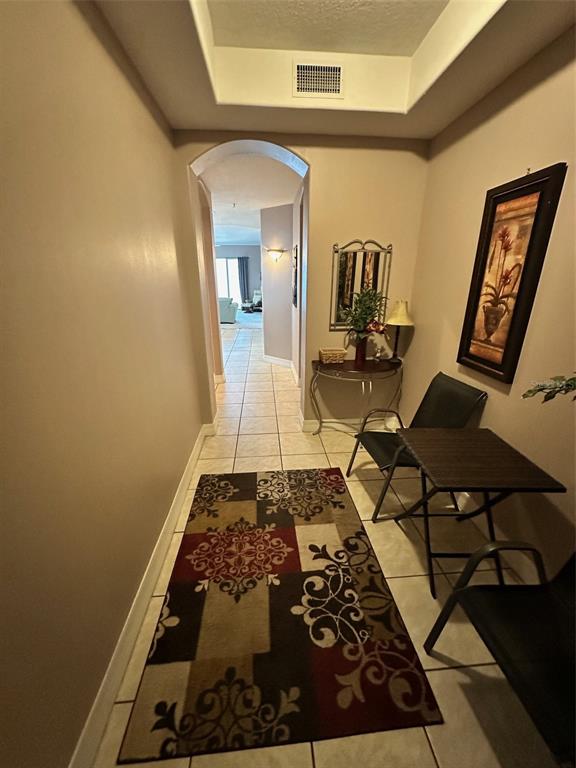 A tiled entryway leads through an arched doorway into a living area with a rug — 711 S ATLANTIC AVENUE UNIT 701, NEW SMYRNA BEACH, FL