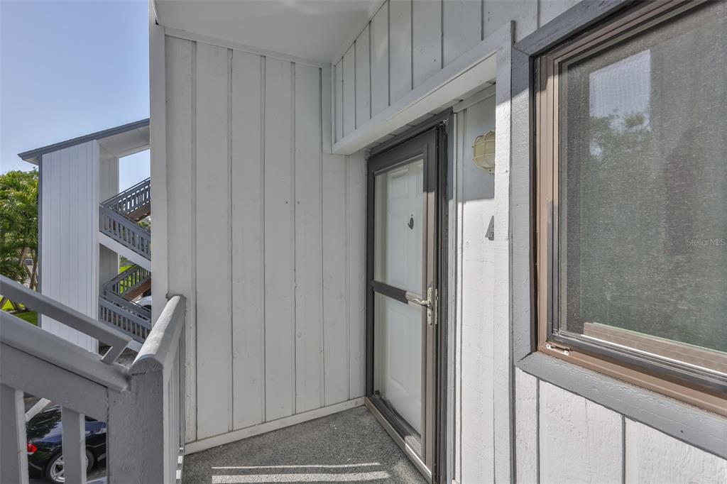 An exterior view of an apartment entryway with a screen door and a window — 812 BAHIA DEL SOL DRIVE UNIT A, RUSKIN, FL