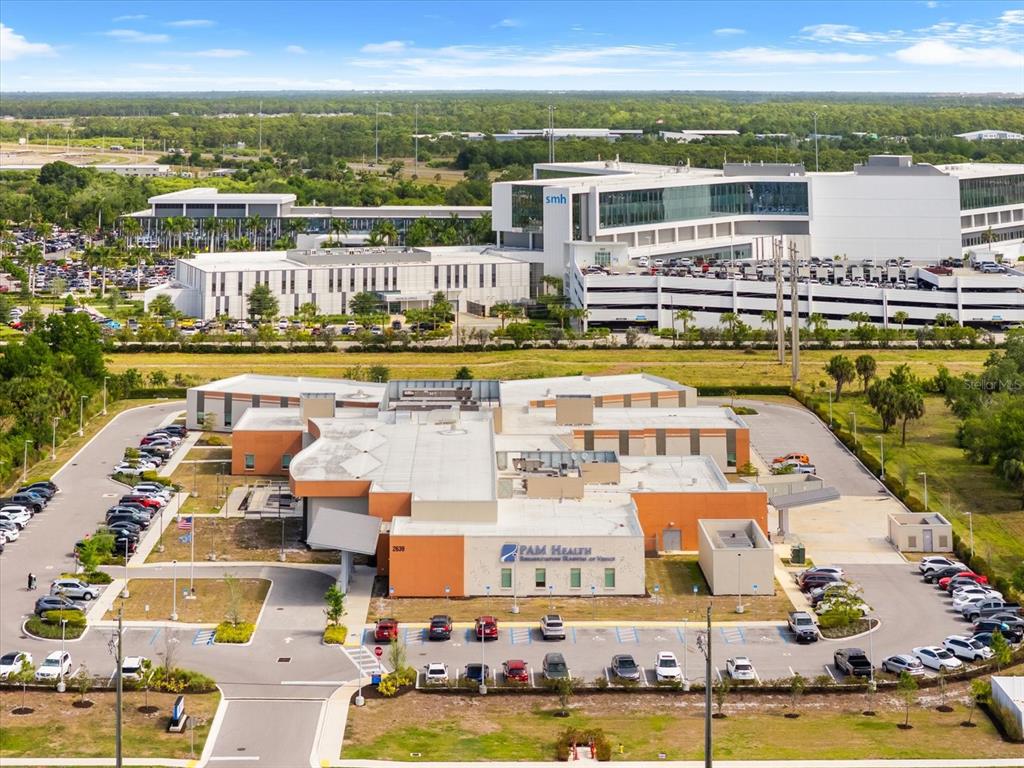 An aerial view shows a PAM Health facility with a parking lot and a hospital nearby — 2900 CURRY LANE, NOKOMIS, FL