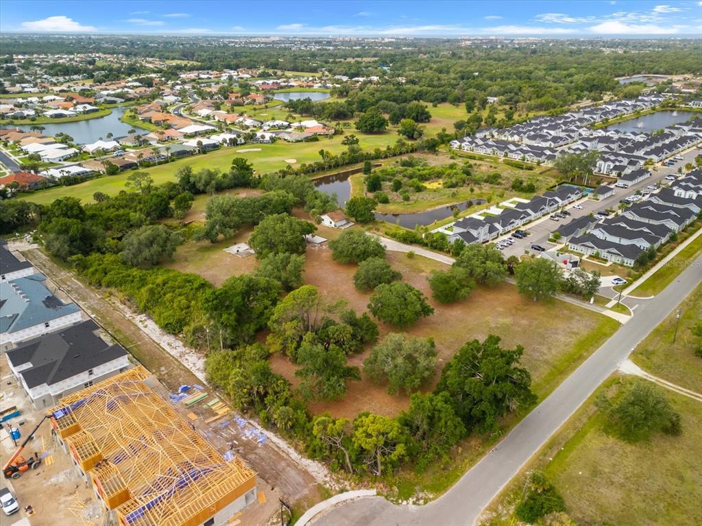 An aerial view shows a vacant lot surrounded by residential developments and a small pond — 2900 CURRY LANE, NOKOMIS, FL