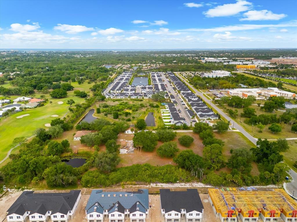 An aerial view shows a residential development with townhomes, ponds, and surrounding green space — 2900 CURRY LANE, NOKOMIS, FL
