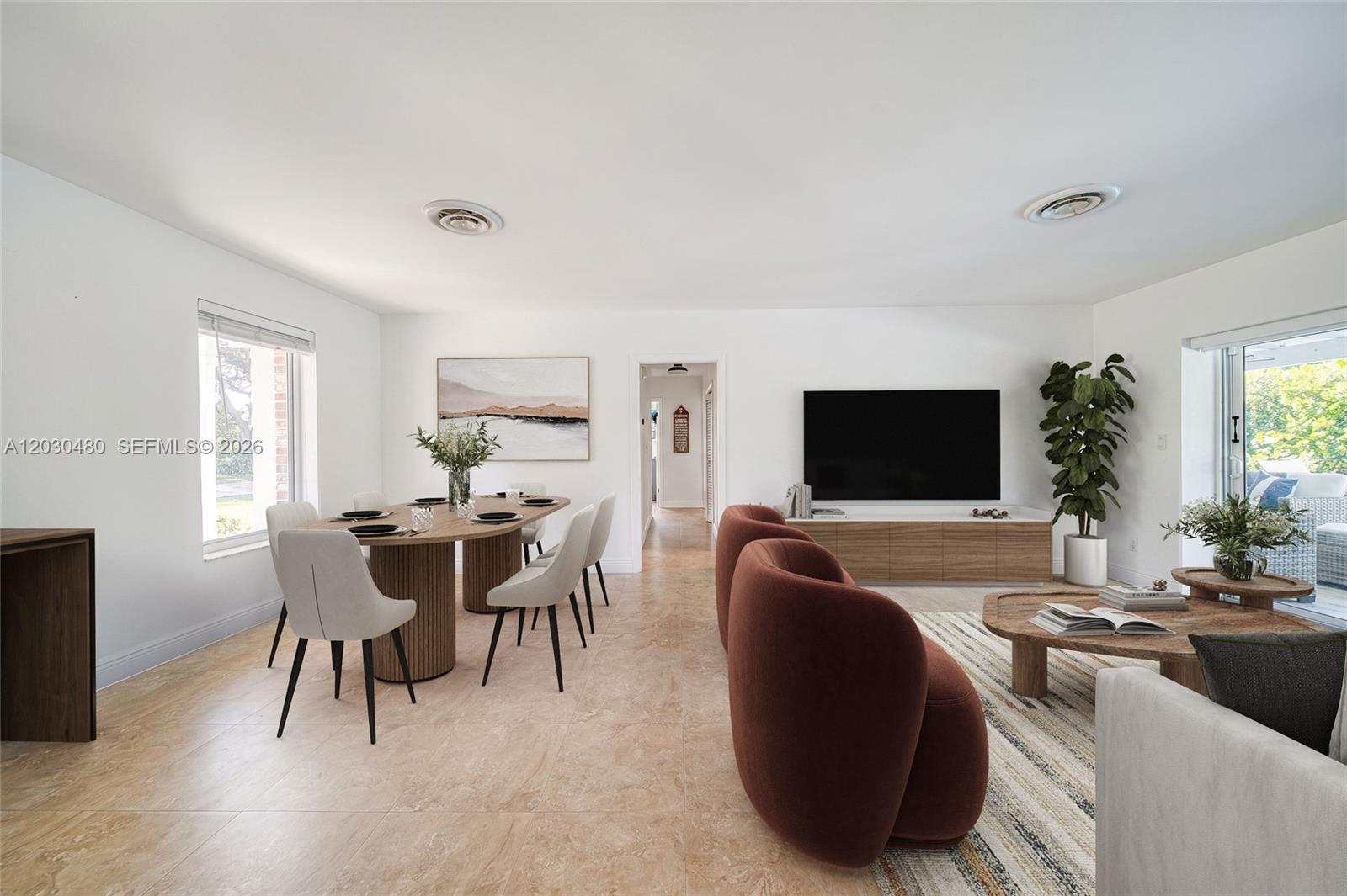 An open-concept living and dining area features tile flooring, modern furniture, and a wall-mounted television — 10600 SW 80th Ct, Miami FL 33156, MIAMI, FL