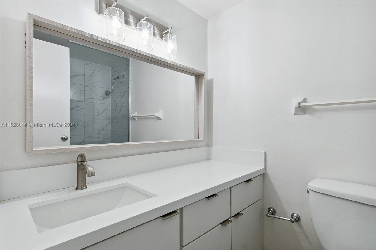 A modern bathroom features a white vanity, a large mirror, and a tiled shower — 1000 West Ave # 821, Miami Beach FL 33139, MIAMI BEACH, FL