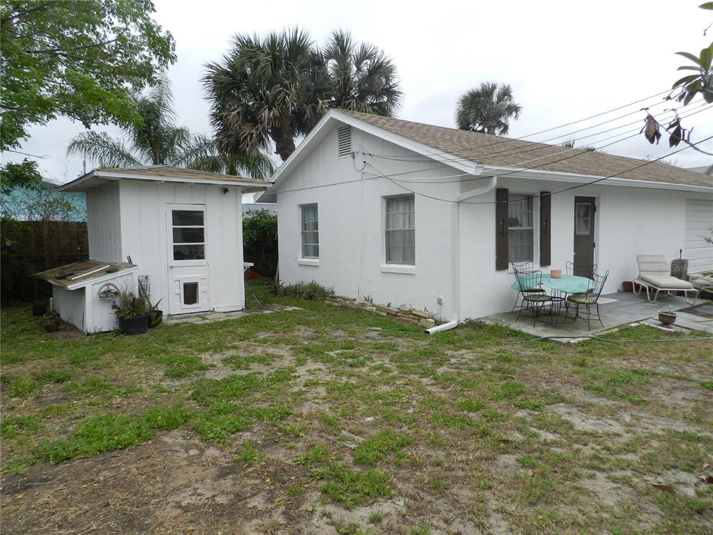 A white house with a detached shed and a small patio in a grassy backyard — 805 OCEAN AVENUE, NEW SMYRNA BEACH, FL