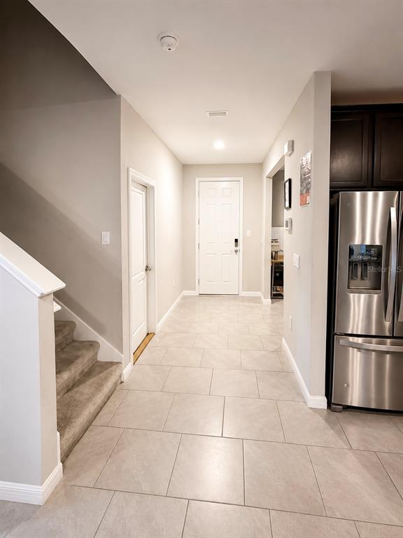 A tiled entryway features a staircase, a white front door, and a stainless steel refrigerator — 3817 SUNNY SPRING STREET, PLANT CITY, FL