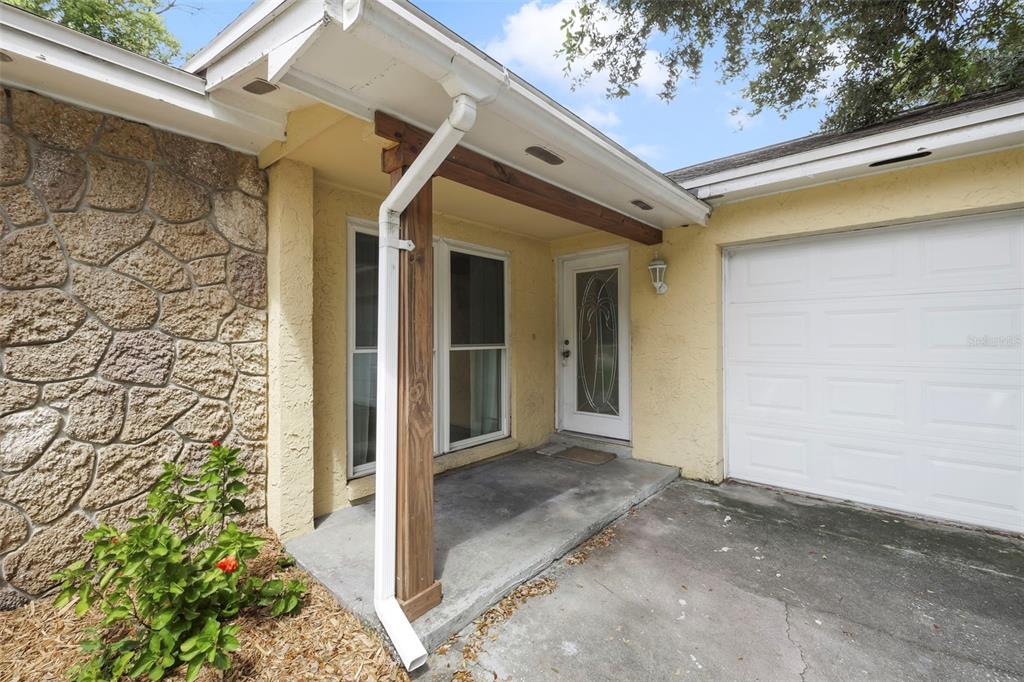 The exterior of a house features a stone facade, a concrete porch, and a garage — 1530 RAVANA DRIVE, ORLANDO, FL