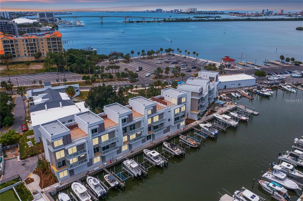 An aerial view of modern waterfront townhomes with private boat slips along a marina — 864 N OSCEOLA AVE, CLEARWATER, FL