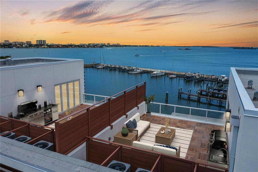 An elevated rooftop terrace features outdoor seating, a grill station, and views of the water — 864 N OSCEOLA AVE, CLEARWATER, FL
