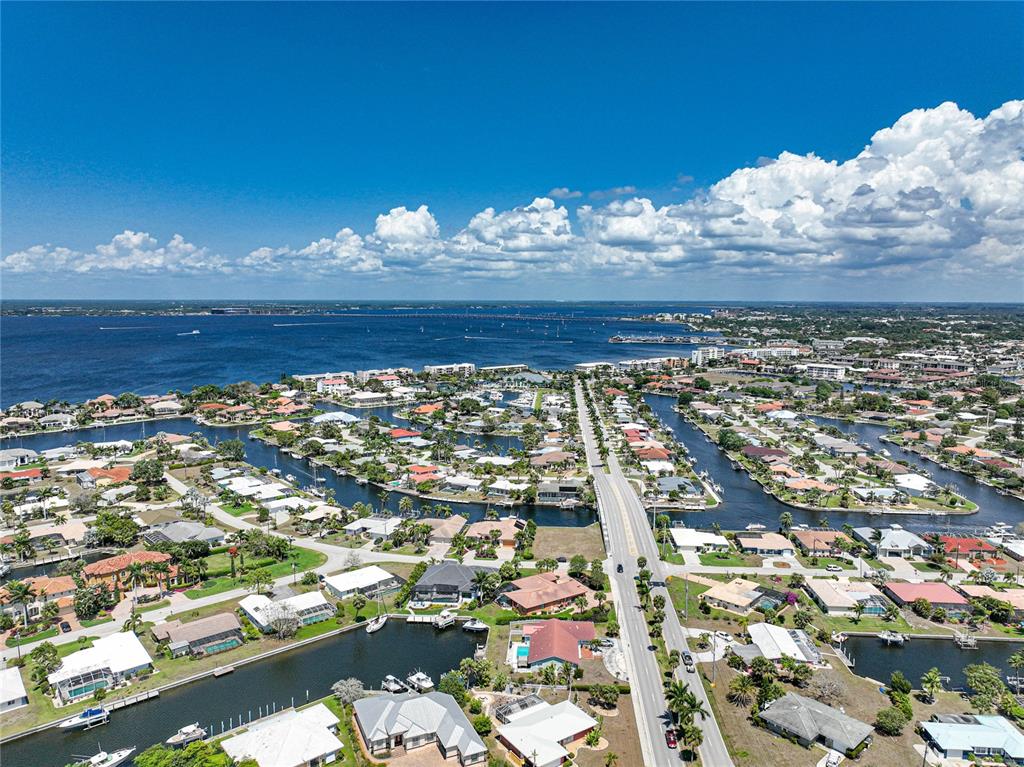 An aerial view shows a residential neighborhood with canals, houses, and a bridge — 197 GULFVIEW ROAD, PUNTA GORDA, FL