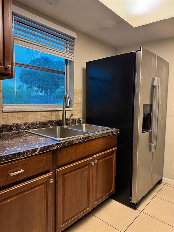 A kitchen features a stainless steel refrigerator, a double-basin sink, and dark wood cabinetry — 6080 22ND AVENUE N UNIT 5, ST PETERSBURG, FL