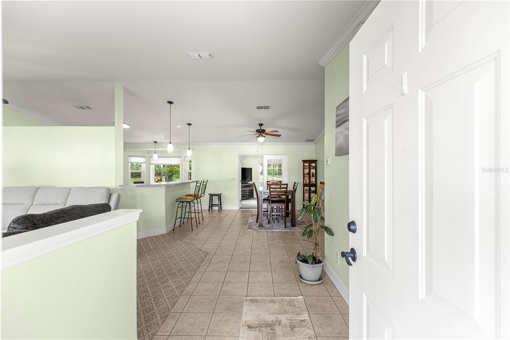 An open-concept living and dining area with tile floors, a breakfast bar, and light walls — 5968 SW 103 LOOP, OCALA, FL