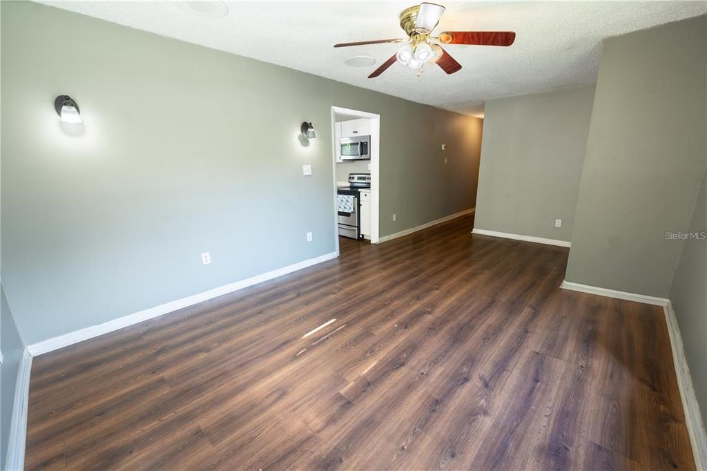 An empty room with wood-look flooring, light green walls, and a ceiling fan — 535 W DIVISION STREET, DELAND, FL