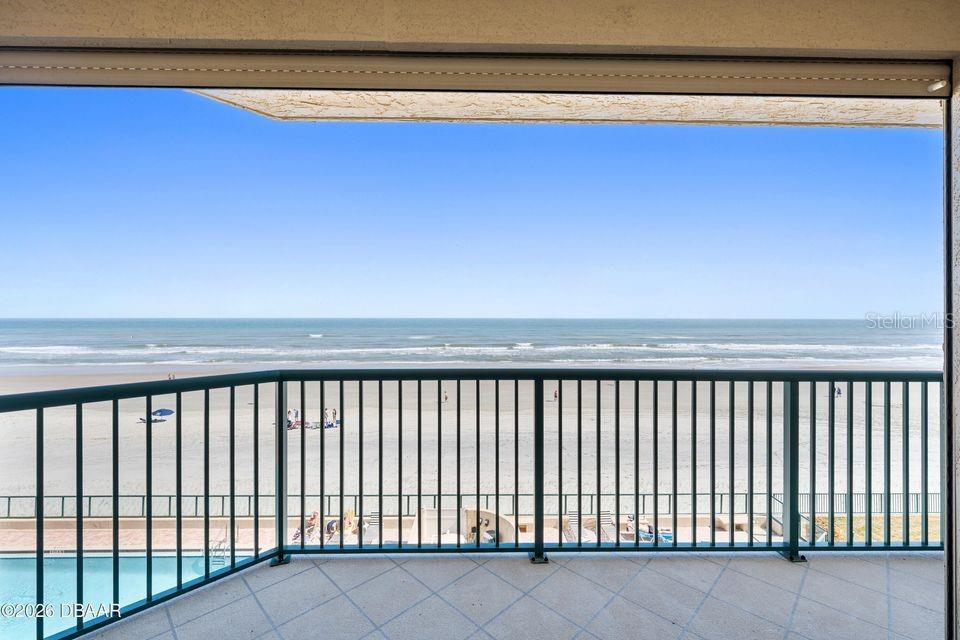 A balcony with a metal railing overlooks a sandy beach and the ocean — 4575 S ATLANTIC AVENUE UNIT 6303, PORT ORANGE, FL