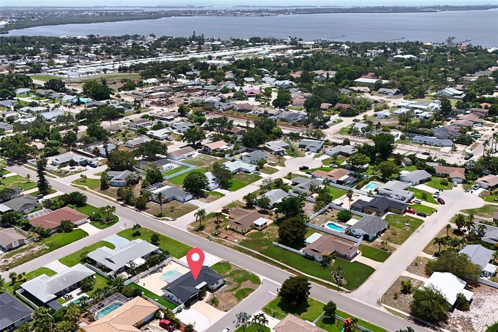 An aerial view shows a residential neighborhood with a marked house featuring a swimming pool — 7221 15TH AVENUE DRIVE W, BRADENTON, FL