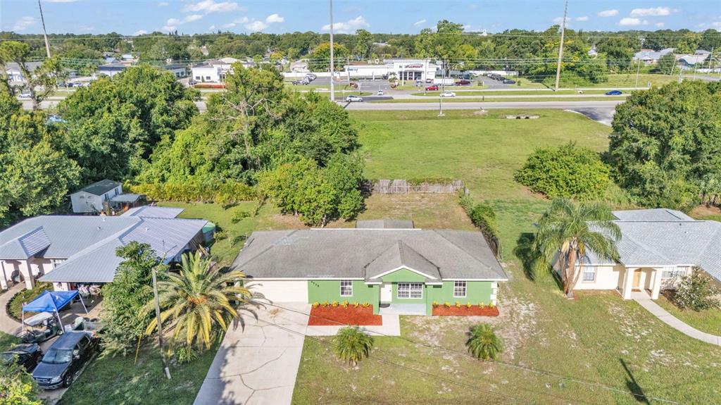 An aerial view shows a green single-story house with a driveway and surrounding residential landscaping — 4515 STARFISH AVENUE, SEBRING, FL