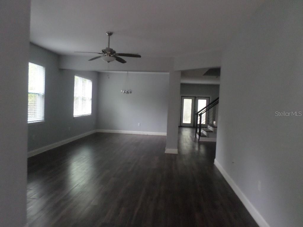 An open living area features dark wood flooring, light gray walls, and a ceiling fan — 2773 RED WING VILLAGE, DELAND, FL