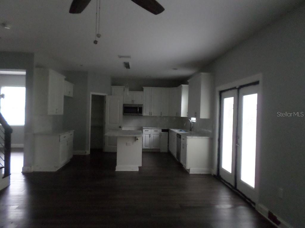 A kitchen with white cabinets, a center island, and dark wood floors — 2773 RED WING VILLAGE, DELAND, FL