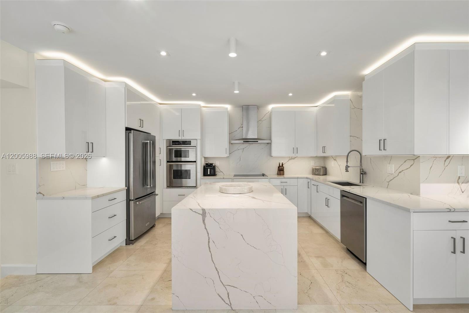 A modern kitchen features white cabinets, marble-patterned countertops, a central island, and stainless steel appliances — 1830 S Ocean Dr # 5103, Hallandale Beach FL 33009, HALLANDALE BEACH, FL