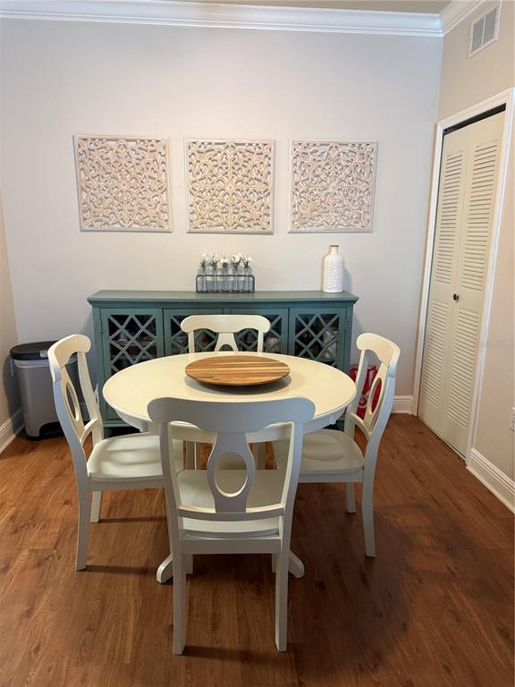 A dining area features a round white table, four chairs, and a teal sideboard cabinet — 1300 EASTERN PECAN PLACE UNIT 107, WINTER GARDEN, FL