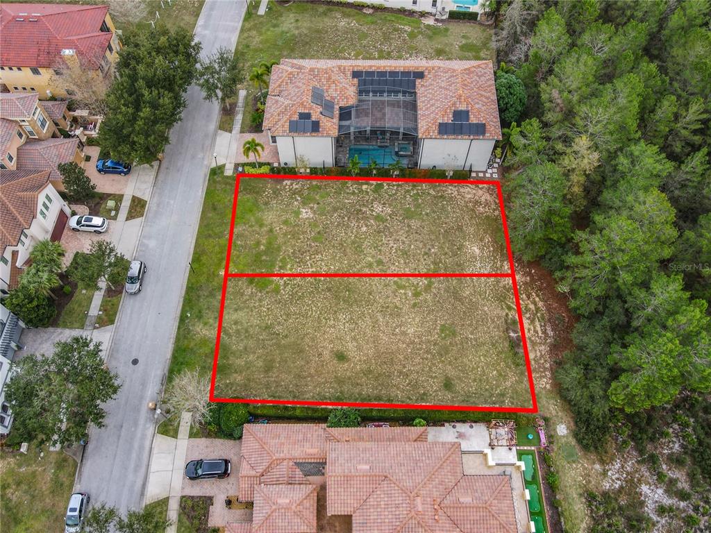 An aerial view shows two adjacent vacant residential lots outlined in red between two houses — 1113 WATSON COURT, KISSIMMEE, FL