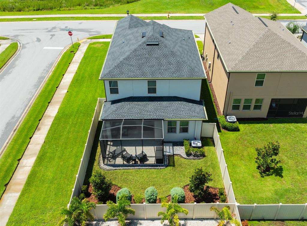 An aerial view shows the back of a two-story house with a screened-in patio — 8625 WINNING FIELDS ROAD, NEW PORT RICHEY, FL