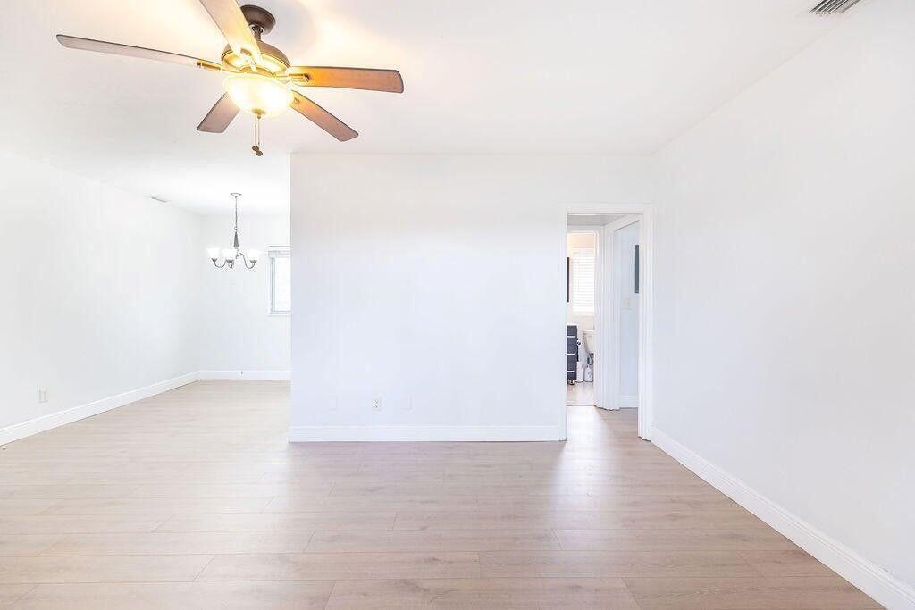A bright, empty room with light wood-look flooring, white walls, and a ceiling fan — 426 NE 7th Avenue # 2b, Delray Beach FL 33483, DELRAY BEACH, FL