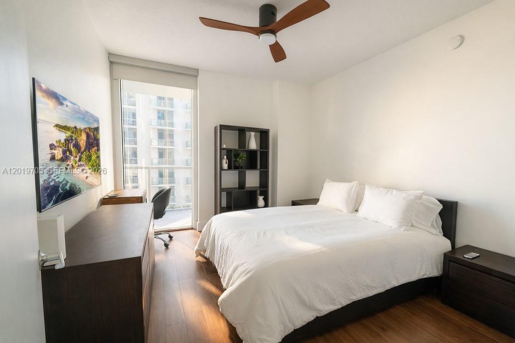 A bedroom features a bed, a desk, a bookshelf, and a wall-mounted television — 1050 Brickell Ave # 2210, Miami FL 33131, MIAMI, FL