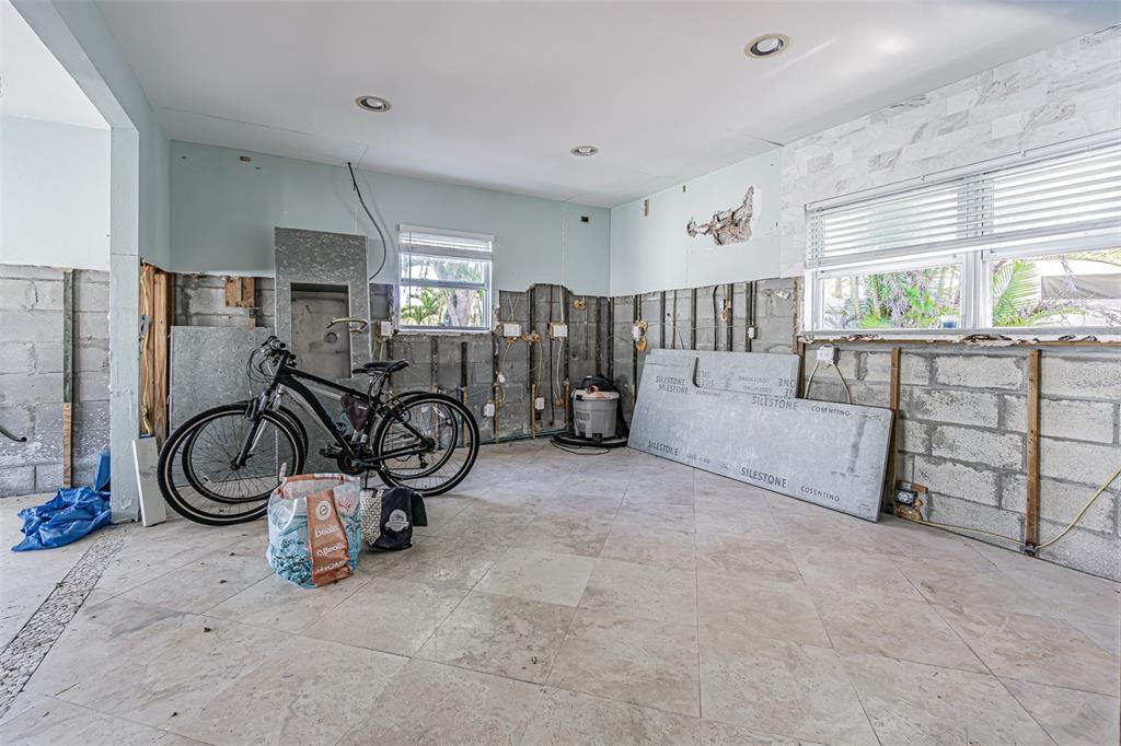 An unfinished room with exposed concrete block walls, tile flooring, and a bicycle — 16101 4TH STREET E, REDINGTON BEACH, FL