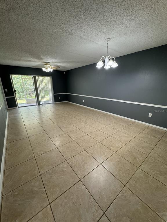 An empty room features dark gray walls, white chair rail molding, and beige tile flooring — 13815 TIMBERLAND DRIVE UNIT 103, ORLANDO, FL
