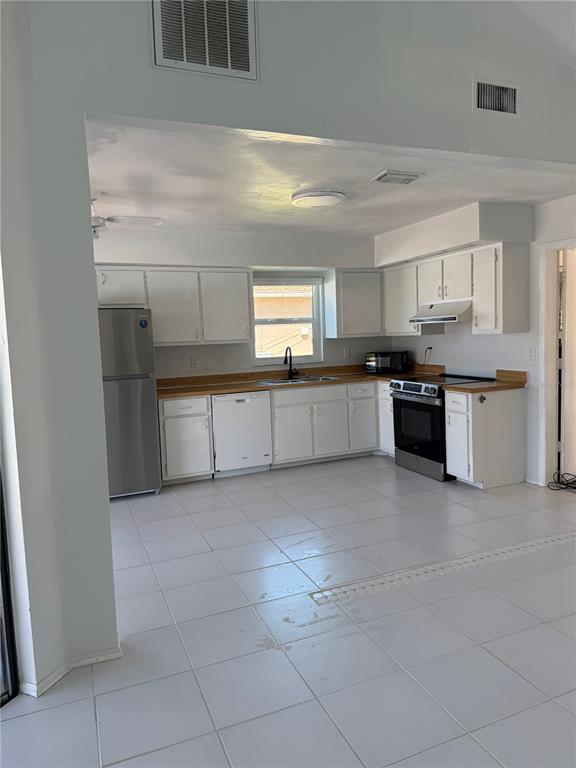 A kitchen with white cabinets, stainless steel appliances, and white tile flooring — 32 NE 13TH PLACE, CAPE CORAL, FL