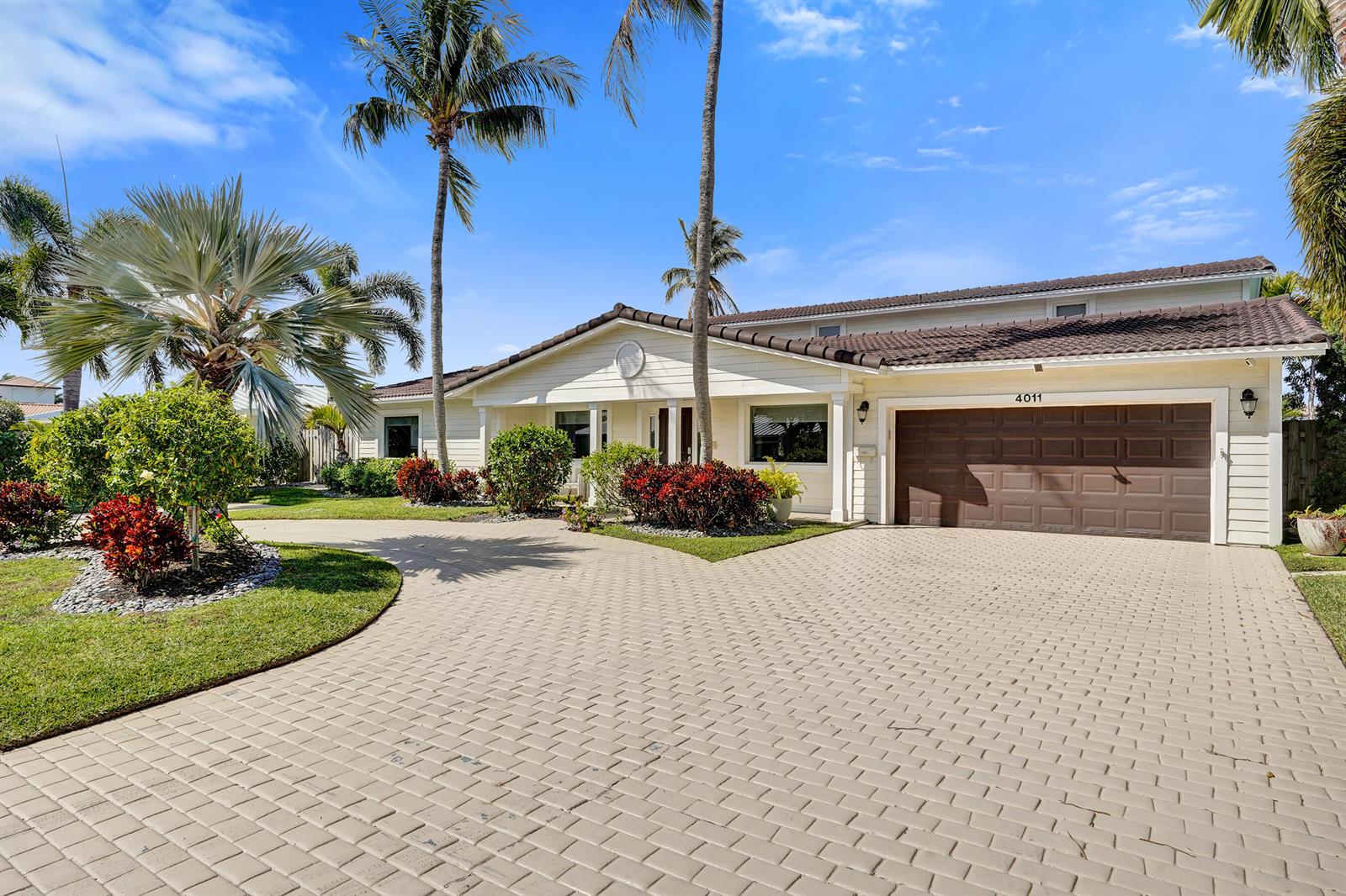 A living room with a grey sectional sofa, wood coffee table, and view of a pool — 4011 NE 26th Avenue, Lighthouse Point FL 33064, LIGHTHOUSE POINT, FL
