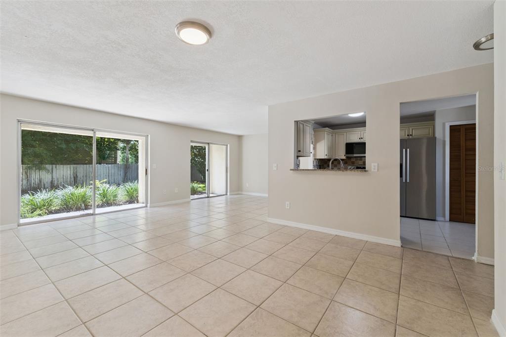 A living room features tile floors, a beige sofa, an armchair, and a sliding glass door — 600 NORTHERN WAY UNIT 201, WINTER SPRINGS, FL