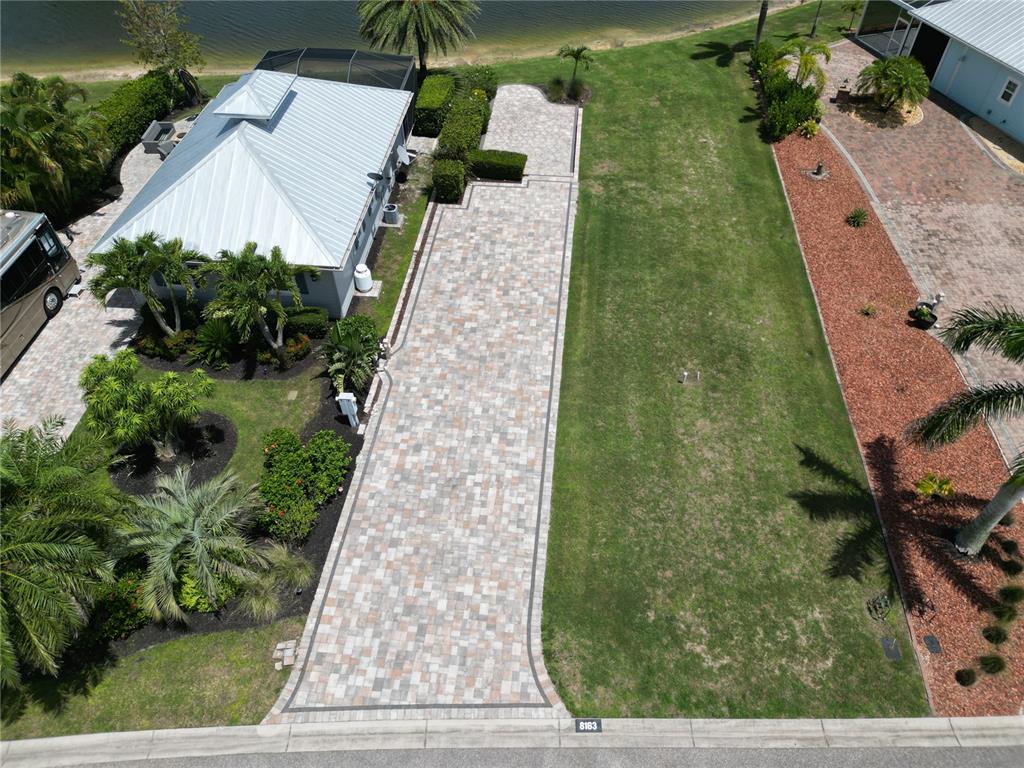 An aerial view shows a paved driveway next to a grassy lot and a house — 8163 SW SAND CRANE CIRCLE LOT 6, ARCADIA, FL