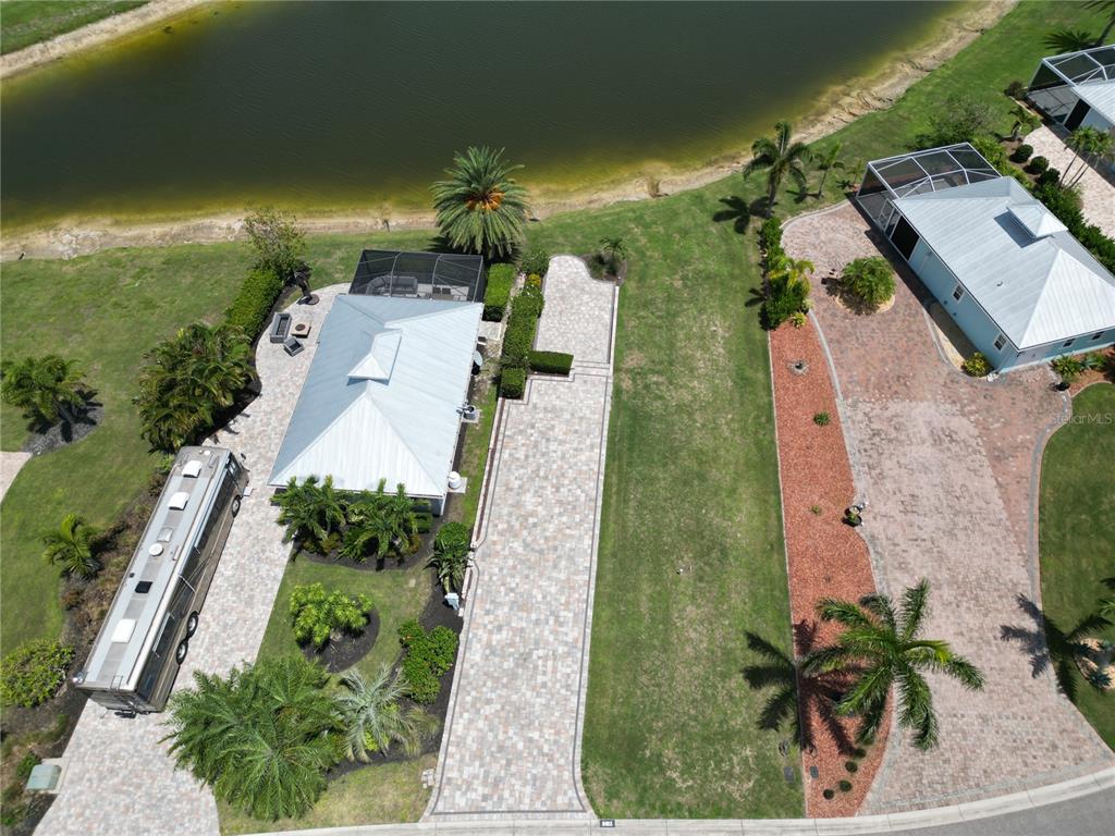 An aerial view shows two houses with paved driveways, landscaping, and a large pond — 8163 SW SAND CRANE CIRCLE LOT 6, ARCADIA, FL