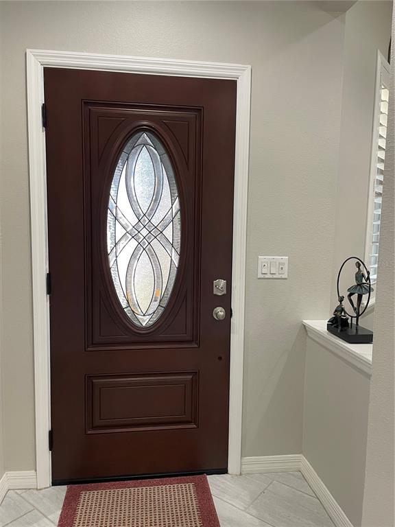 A dark brown front door with an oval glass insert sits in a neutral-walled entryway — 436 PONTEVEDRA ROAD, DAVENPORT, FL