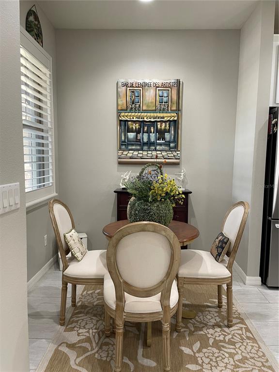 A dining nook features a round wooden table, four upholstered chairs, and wall art — 436 PONTEVEDRA ROAD, DAVENPORT, FL
