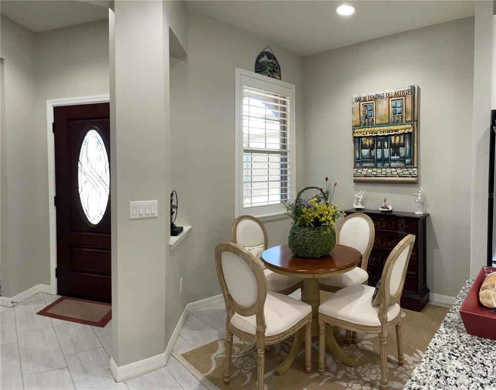 A dining area features a round wooden table, four chairs, and a painting on the wall — 436 PONTEVEDRA ROAD, DAVENPORT, FL