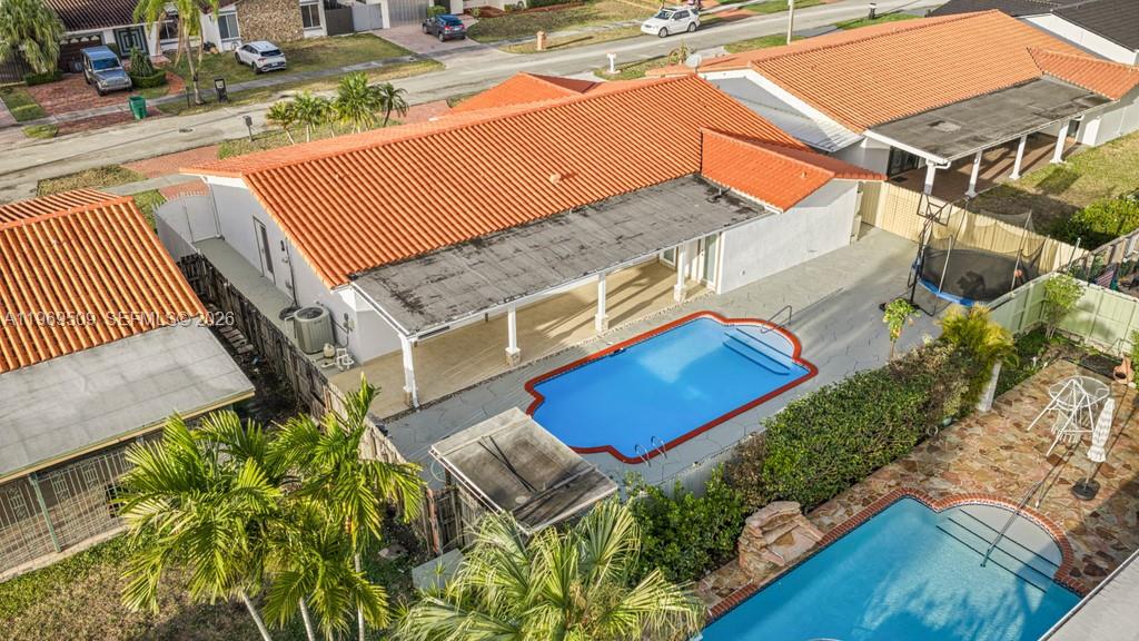 An aerial view shows a house with a red tile roof and a backyard pool — 13170 SW 20th St, Miami FL 33175, MIAMI, FL